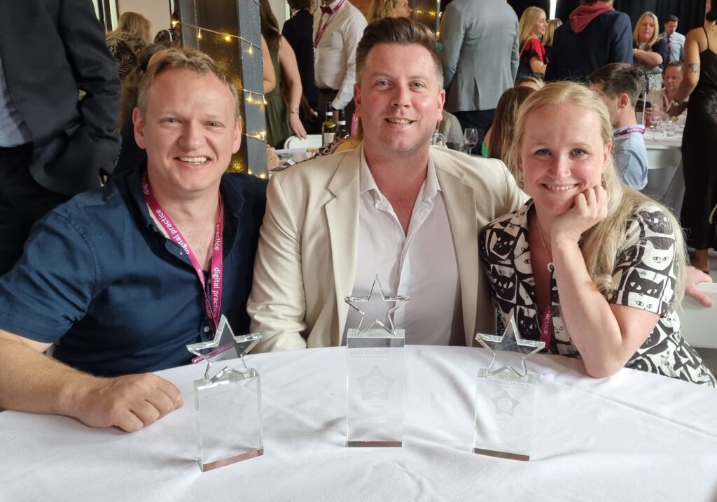 3 members of the Willows team sitting at a table dressed smartly with their awards from Best Vet Awards placed in front of them